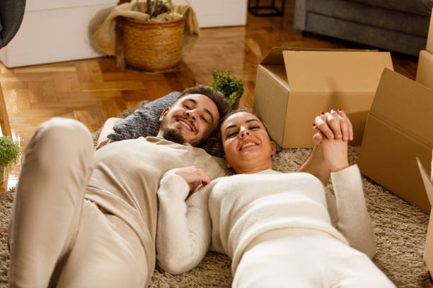istock Couple lying on the floor, embraced, holding hands, smiling at camera 1399499805