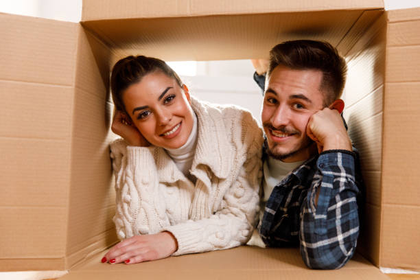 istock Joyful couple lying inside the cardboard box and happily smiling at camera 1399499829