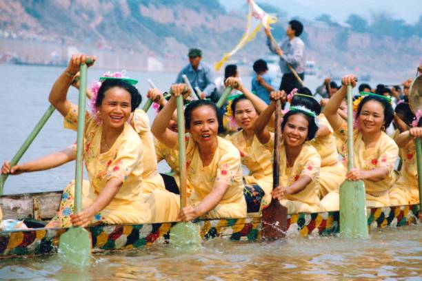 In the 1990s,Dragon boat racing in the Water Splashing Festival in Xishuangbanna,a group of women racing in a dragon boat In China it is called Water Splashing Festival, also known as Songkran festival in Thailand.The main aboriginal people in Xishuangbanna, Yunnan province, China are called Dai Tribe, aiso is Thai  Ethnicity.The festival lasts for several days, with dragon-boat races, water splashing, traditional songs and dances, fairs and more.Film photo in April 1995,Xishuangbanna,Southern Yunnan xishuangbanna stock pictures, royalty-free photos & images