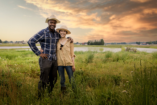 An African American man with his Japanese wife pictured together in the countryside at sunset.