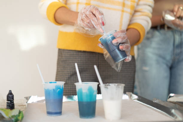 istock Epoxy resin, different blue color in cup for casting stabilizing wood, abstract art. Process of making accessory from resin.Mixing colorful of resin chemical in plastic cup 1399500144