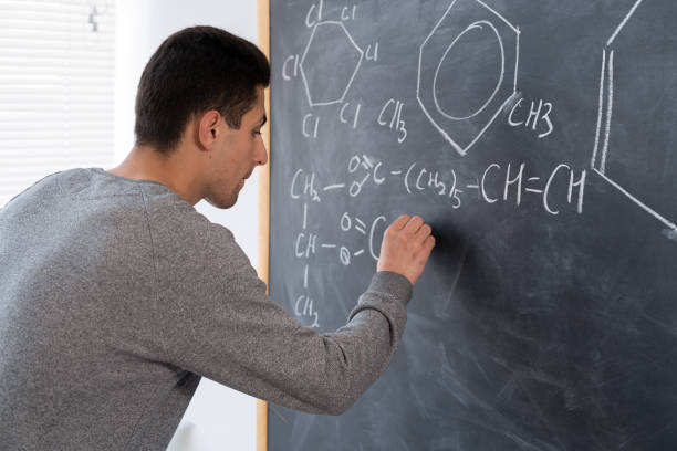 main d’un professeur de chimie arabe avec des formules et des éléments de dessin à la craie, des signes et des symboles de chimie, concept de formation de chimiste - formula blackboard complexity scientist photos et images de collection