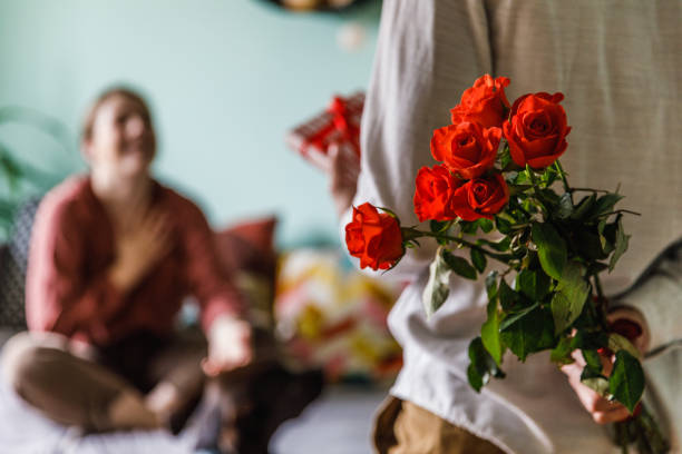 istock Man holding red roses behind back, as a surprise for his girlfriend 1399503160