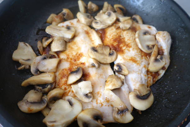 Spicy turkey escalope and browned button mushrooms being cooked