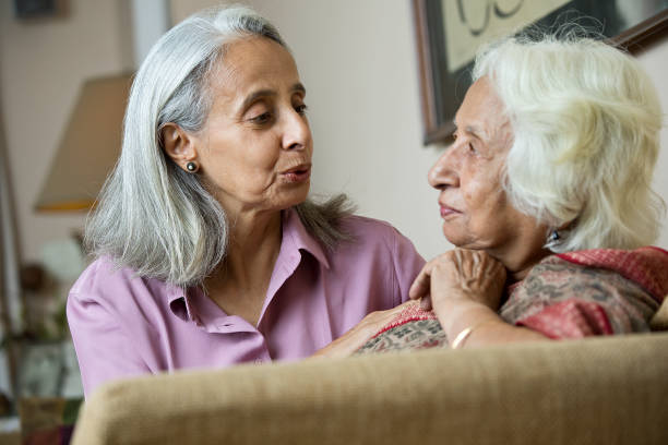 женщина утешает свою старую мать дома - distraught 70s asian ethnicity women стоковые фото и изображения