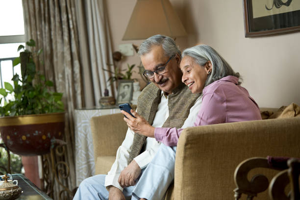 istock Old couple using phone at home 1399509612