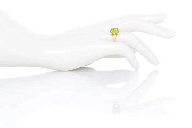 Peridot and Diamond Jewel or gems ring on plastic mannequin female hand. Collection of natural gemstones accessories. Studio shot