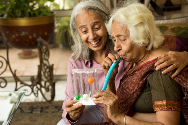 Woman surprised on old friend using spirometer to stimulate lung stock photo