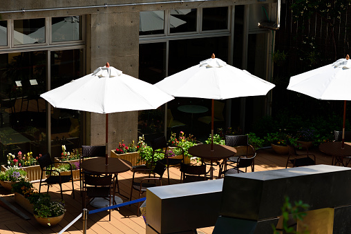 Close-up of sunny patio with garden furniture and parasol.