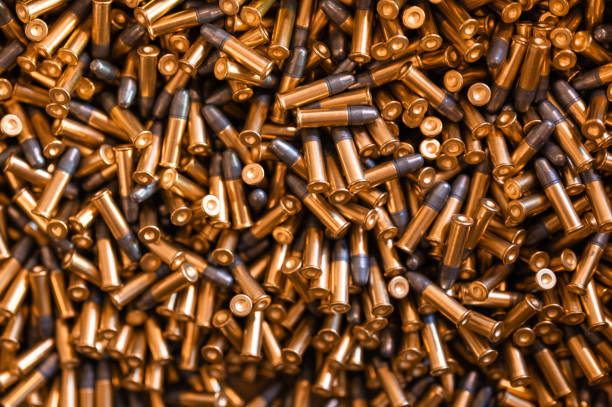 istock Heap of black and golden small-caliber bullets on table 1399521641