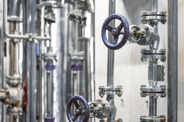 istock Thin metal pipes with small blue valves and flanges at plant 1399521691