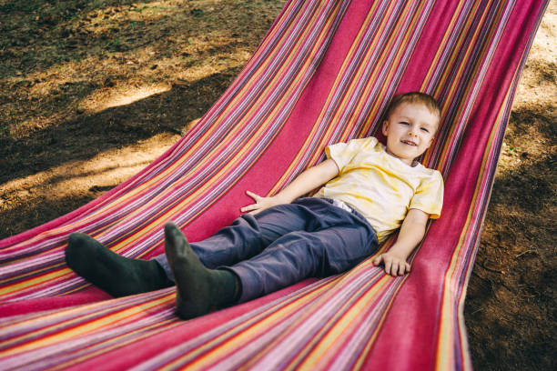 istock Little boy lies in a colored hammock. 1399523457