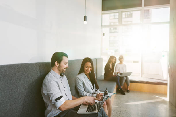 multiracial group of work colleagues sitting and discussing plans and ideas in modern coworking shared business office - chinese ethnicity latin american and hispanic ethnicity multi ethnic group business person imagens e fotografias de stock