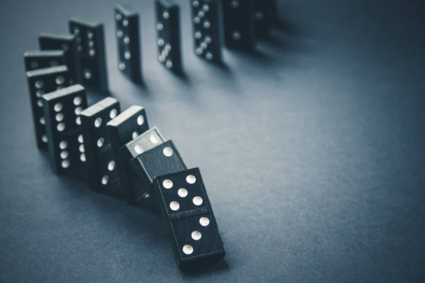 istock Black dominoes chain on dark table background 1399526368
