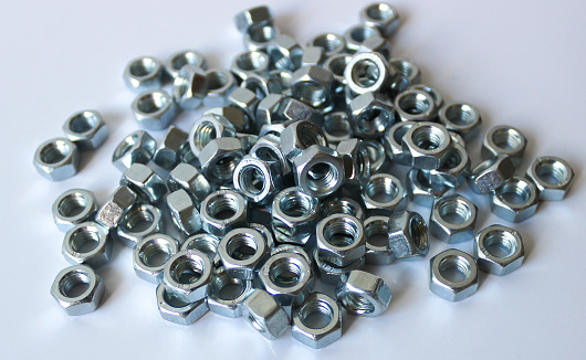Group of small shiny metallic bolts on white background.