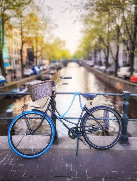 bicicleta en un puente sobre un canal en ámsterdam países bajos - amsterdam canal netherlands dutch culture fotografías e imágenes de stock