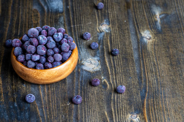 frozen blueberries on a wooden table frozen blueberries on a wooden table, ripe deep-frozen blueberries on a blackboard 2667 stock pictures, royalty-free photos & images