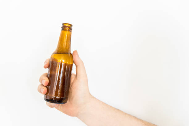 istock A hand holding a beer bottle against a wall 1399530494