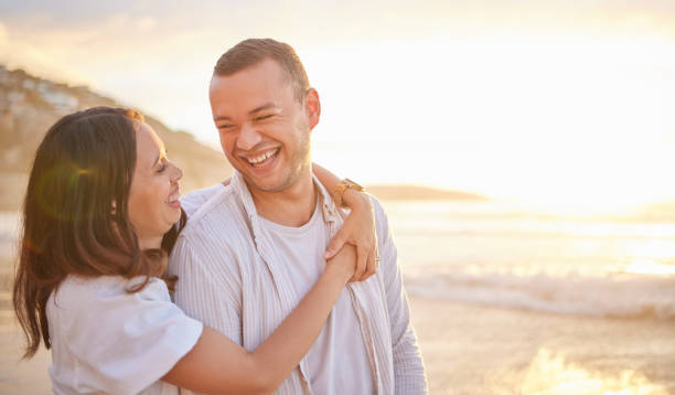 istock Affectionate young mixed race couple sharing an intimate moment on the beach. Happy husband and smiling wife enjoying a summer day by the sea. They love spending time together on the coast at sunset 1399530858