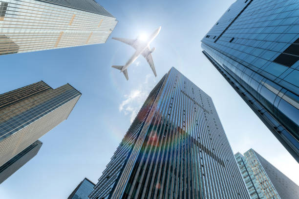 istock airplane fly over modern office buildings with sunshine, low angle view. 1399531865