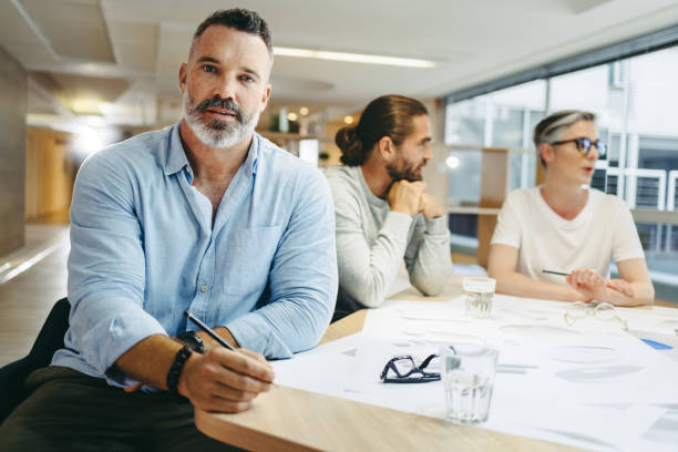 istock Mature achitect sitting in a meeting with his team 1399532026