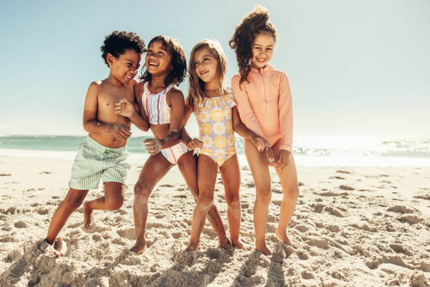 istock Multiethnic kids playing together on beach sand 1399532140
