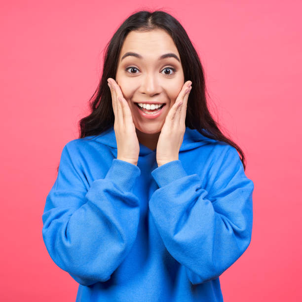 istock Surprised smiling young Korean woman on a pink background. 1399537253