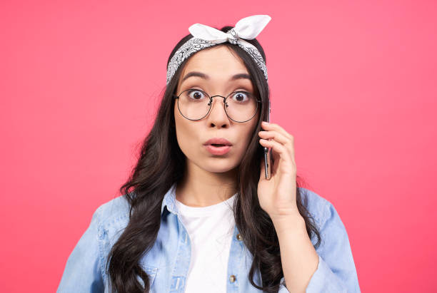 istock A cute girl with a surprised expression speaks on the phone. 1399537265