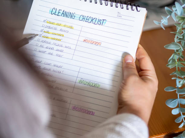 istock Woman planning a spring cleaning checklist routine for household. 1399537422