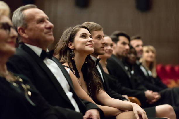 istock Smiling spectators sitting in the theater 1399537605