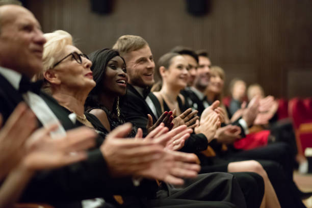 Spectators clapping in the theater, close up of hands Side view of audience clapping hands in opera house. Men and women are watching theatrical performance. They are in elegant wear. gala stock pictures, royalty-free photos & images