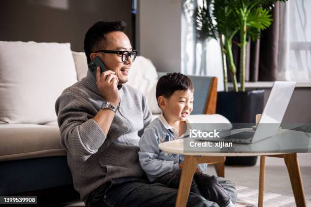 Father With His Son Working Together At Home Stock Photo - Download Image Now - Father, Using Phone, Laptop