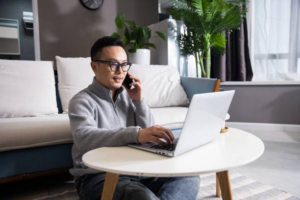istock Asian man working at home talking with mobile phone 1399540638