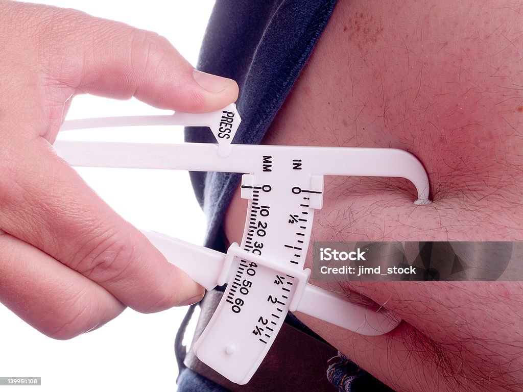 Fat Calipers Fat calipers being used to measure the amount of fat on a belly Adipose Tissue Stock Photo