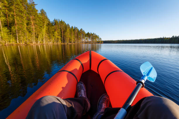 istock A man in a packraft with a paddle on a beautiful forest lake. 1399549580
