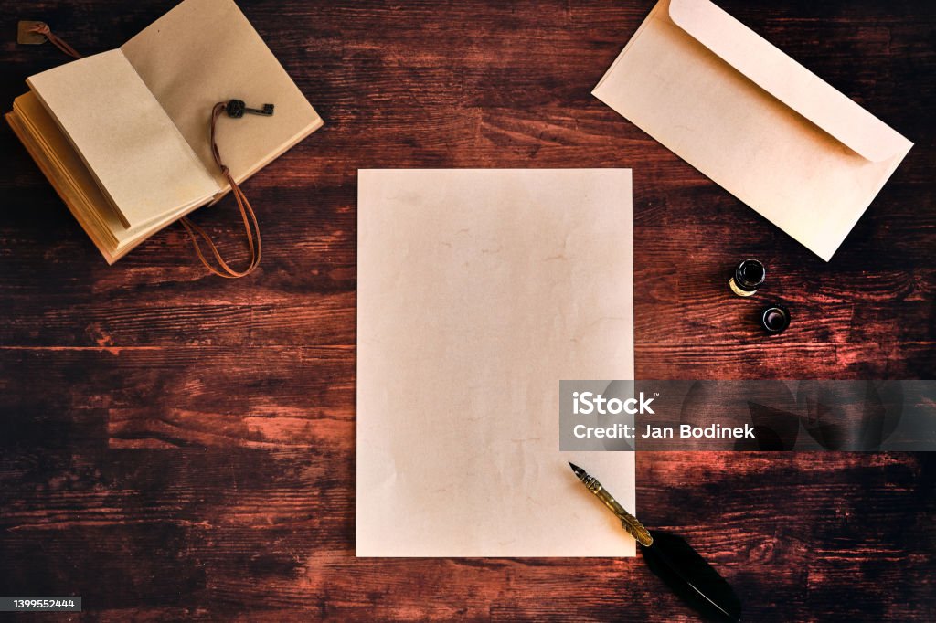 Flatlay with a letter on a wooden table Frame with a letter, note paper and diary on a wooden table High Angle View Stock Photo
