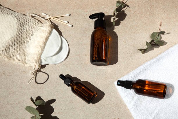 istock Amber clear bottles with cosmetics, cotton pads and sticks on a light background with eucalyptus branches 1399552753