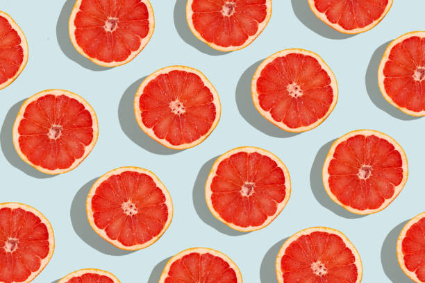 istock Many fresh slices of grapefruits on turquoise background, flat lay. Pattern design 1399553877