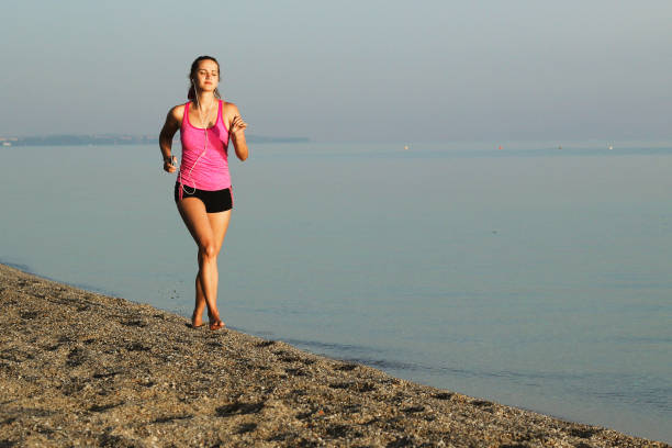 istock Athletic woman running by the sea shore 1399554725