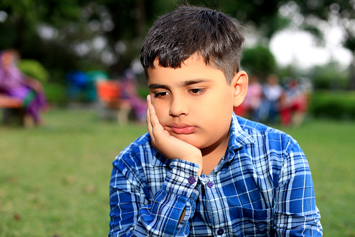 Sulking child portrait outdoor in nature.