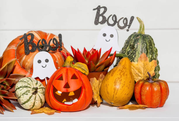 istock Happy Halloween! Pumpkin Jack on the table. Lantern with a carved smile and different attributes of the holiday on a light background.A copy of the place for the text. 1399555810