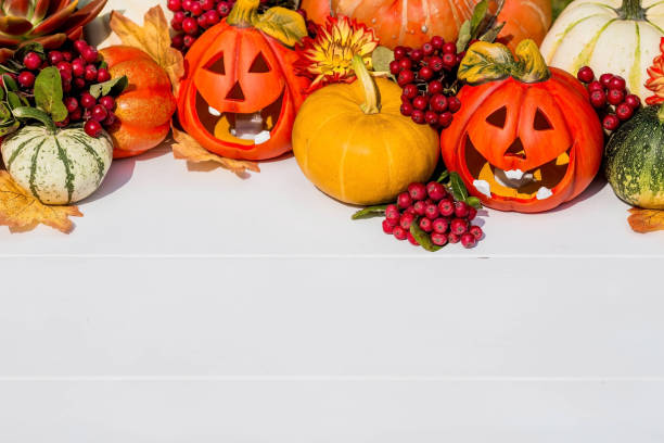 istock Happy Halloween! Pumpkin Jack on the table. Lantern with a carved smile and different attributes of the holiday on a light background.A copy of the place for the text. 1399555811