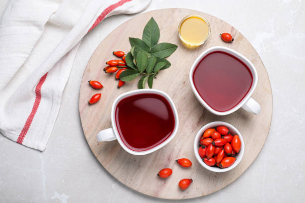 свежий чай из шиповника и ягоды на светлом столе, плоская укладка - organic dried fruit berry fruit dried food стоковые фото и изображения