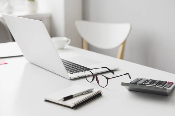 istock Place of work in office, calculator, laptop computer, glasses at office desk 1399557013