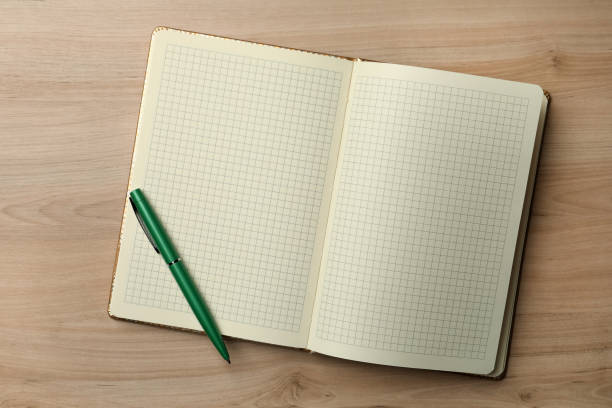 istock Open notebook and pen on wooden table, top view. Personal planning 1399557154