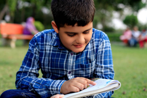 istock Child reading book outdoor in nature 1399557797