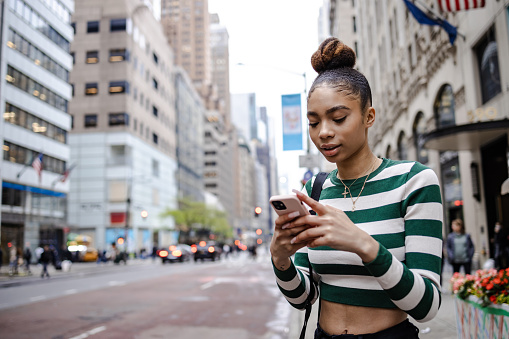 Young woman using smart phone on the street