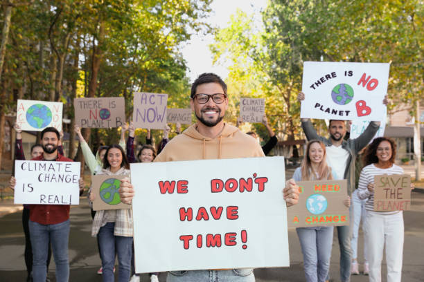 istock Group of people with posters protesting against climate change on city street 1399558609