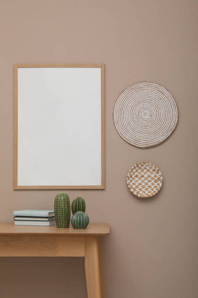 istock Empty frame hanging on beige wall over wooden table with decor. Mockup for design 1399558665