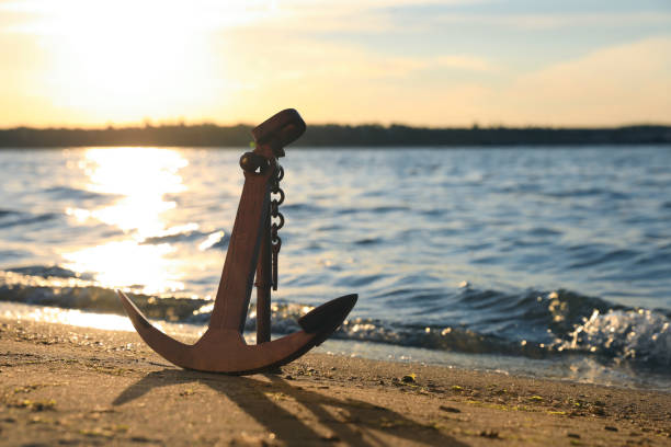 istock Wooden anchor on shore near river at sunset 1399558688